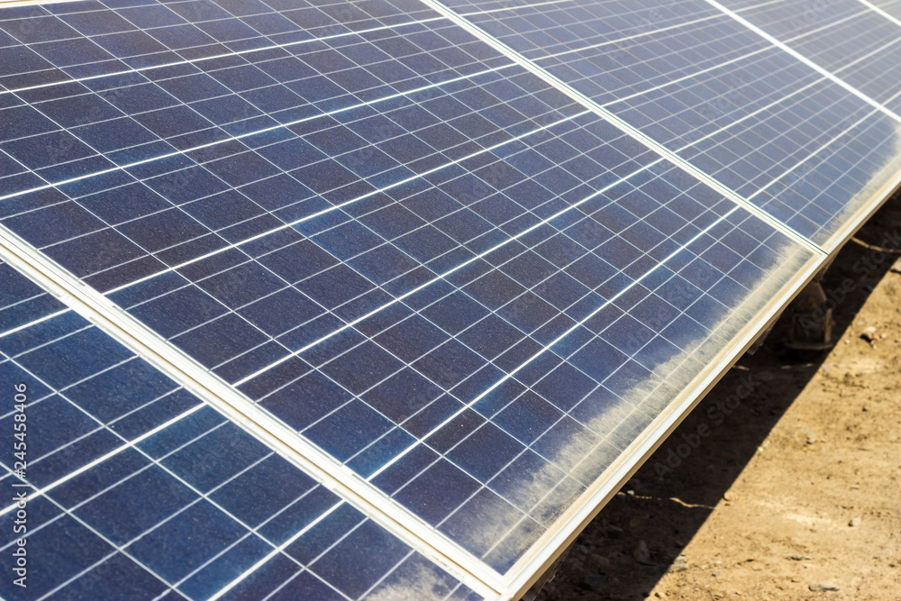 Rows of desert solar panels dulled by a heavy film of dust