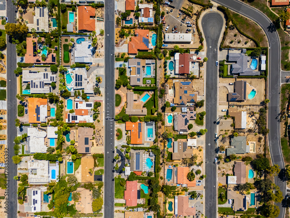 Aerial view of a Palm Springs neighborhood with pools and rooftop solar panels